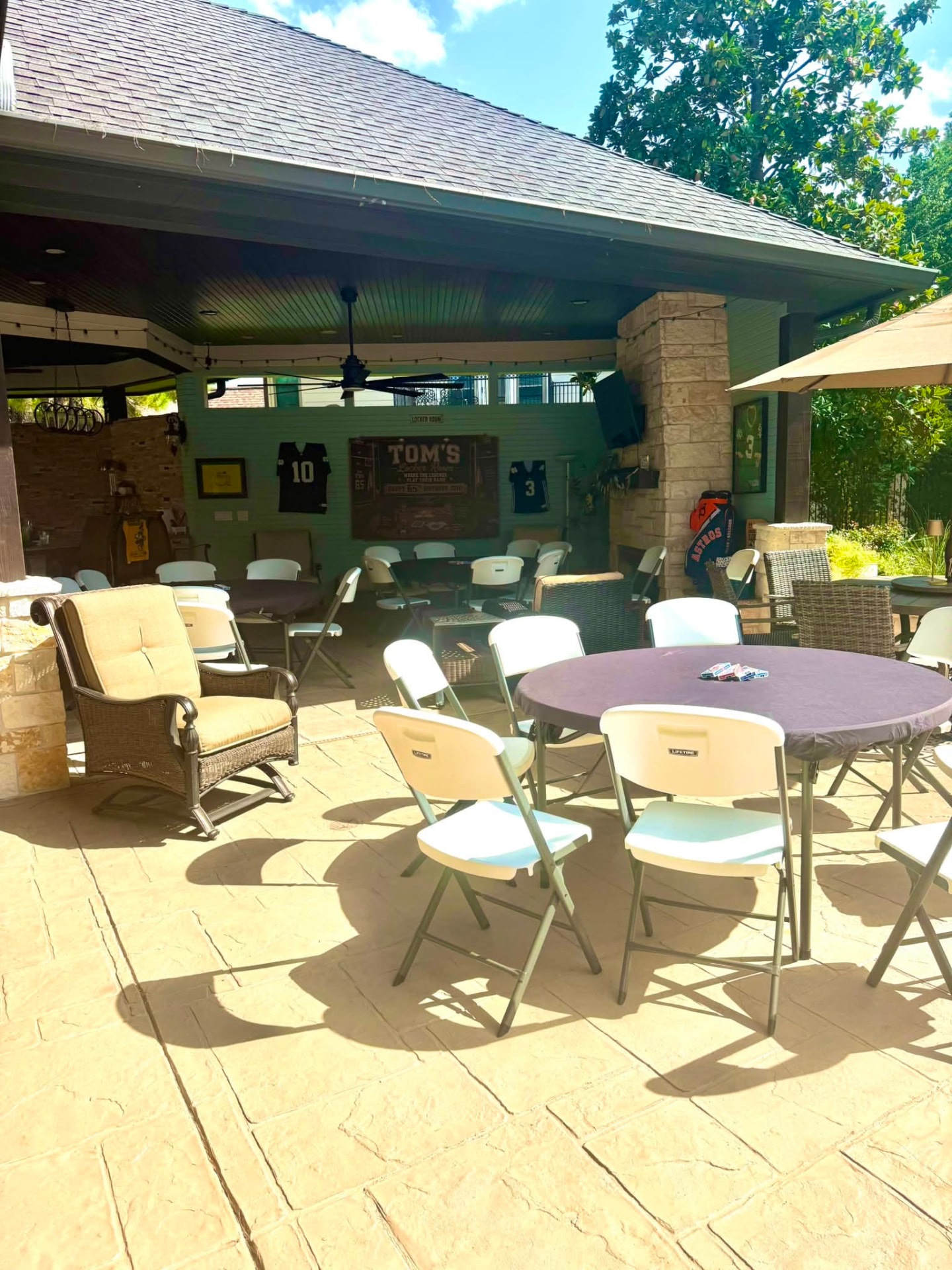 60-inch round table and resin chair rentals on a covered patio in Spring, Texas